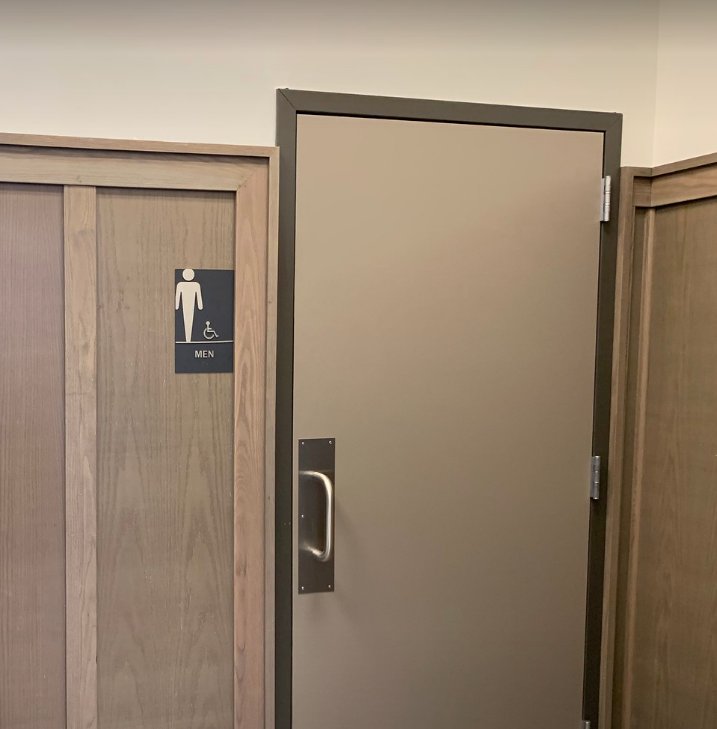 Restroom door and wainscot paneling in woodgrain and solid finishes