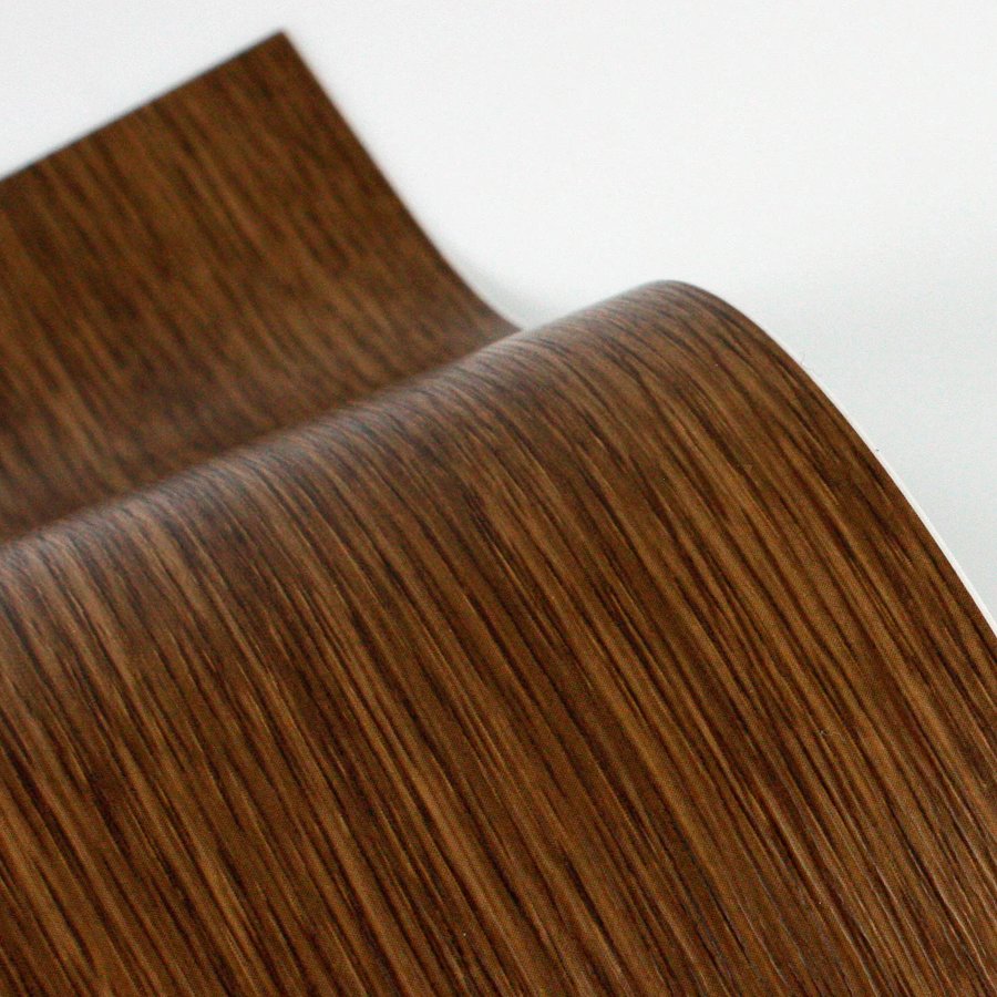 Walnut woodgrain film curling off a sheet